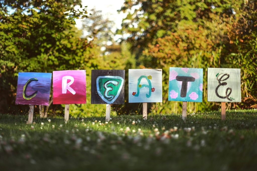 Six hand-painted letters spelling "create"