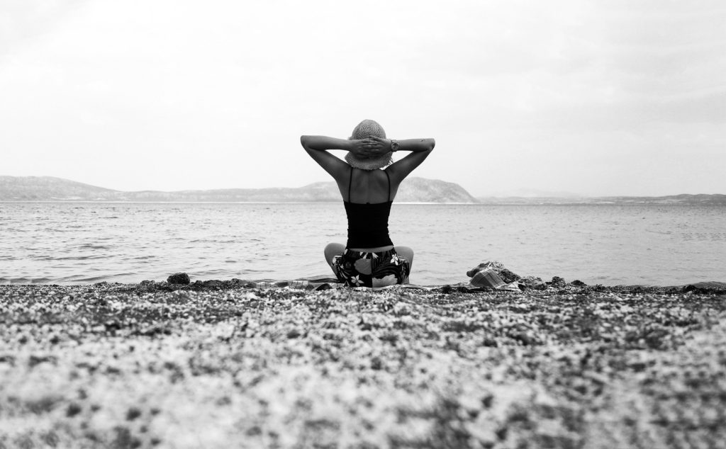 Woman sitting on a rocky beach